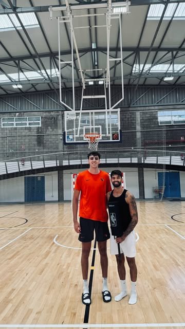 Dani Becerra con un jugador en una pista de baloncesto
